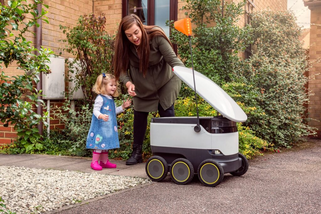 A mother shows a Starship robot to her little girl.